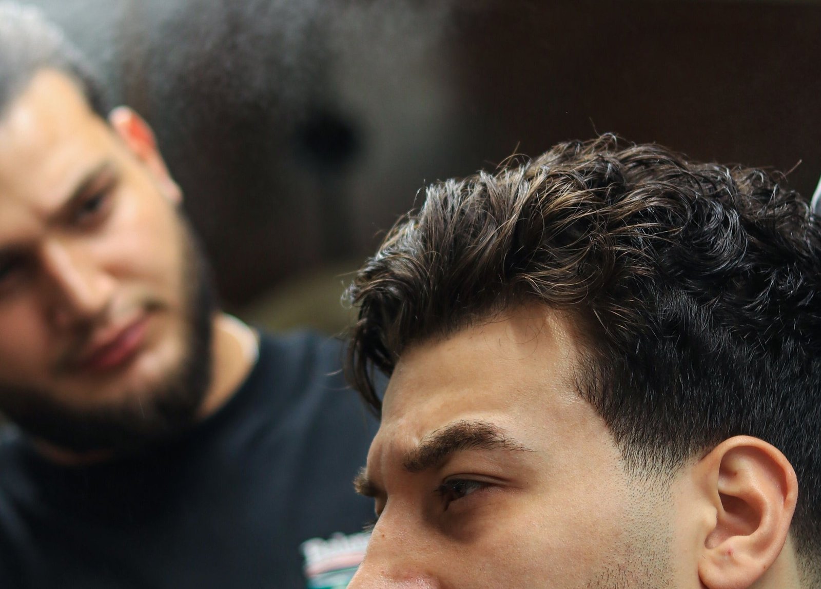 Blackjack barber checking a finished textured haircut at Bay Avenue