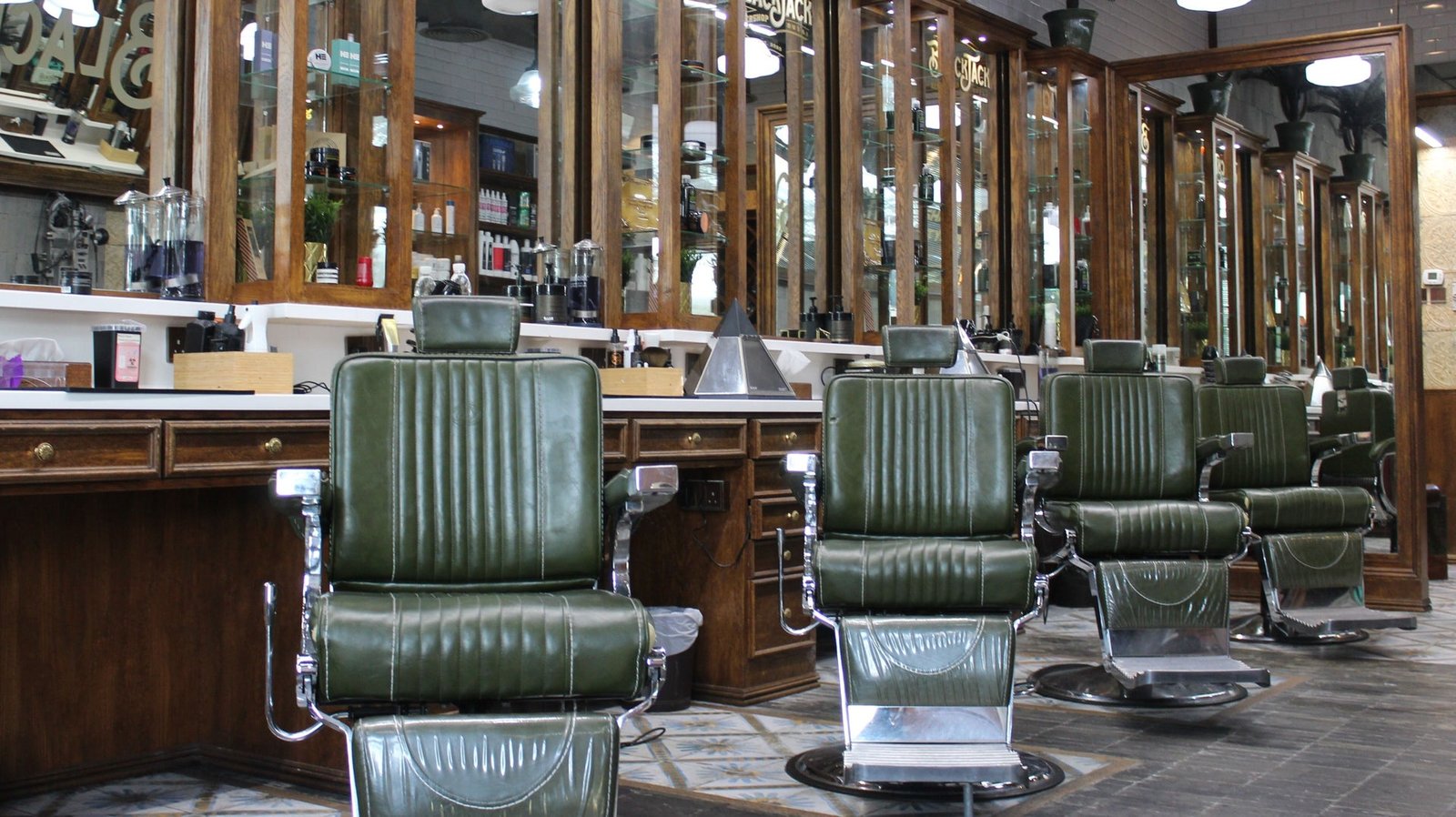 Interior of Blackjack Jumeirah with green leather chairs and wooden grooming stations